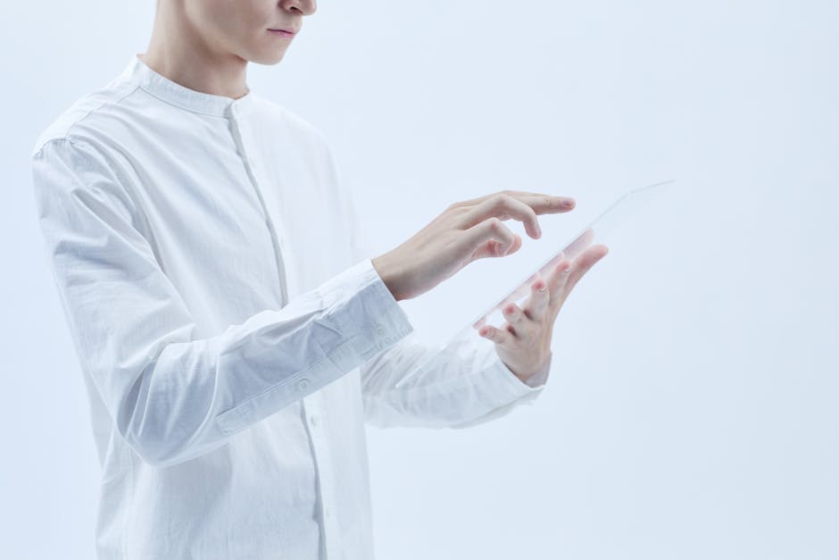 Person interacting with a transparent digital tablet, symbolizing technology and futurism